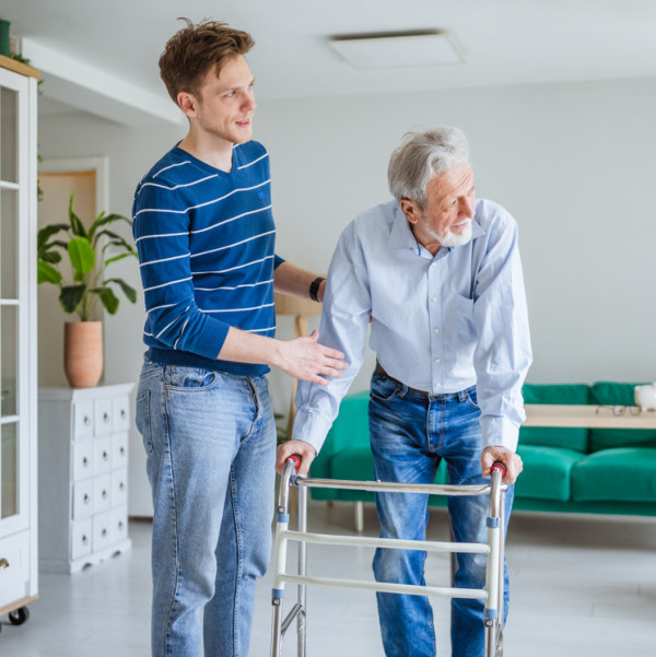 young man helping his granddad with a walker